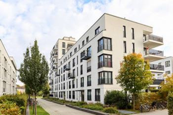 White apartment building surrounded by trees